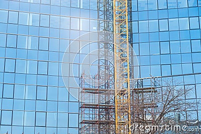 New modern architecture business building construction site with big glass windows facade scaffolds and crane part Stock Photo