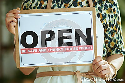 Modern business owner woman in apron showing open sign Stock Photo