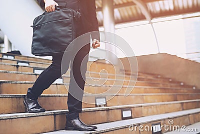 Modern businessman hand holding briefcase computer notebook beside working close up legs Stock Photo