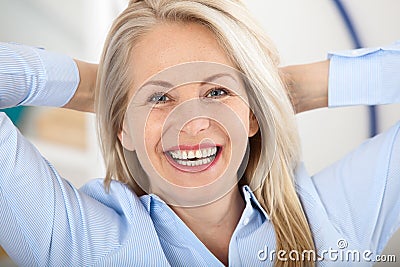 Modern businesswoman. Beautiful middle aged woman looking at camera with smile while siting in the office. Stock Photo