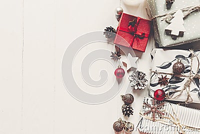 modern christmas wrapped presents with ornaments and cones on white wooden background top view, space text. merry christmas Stock Photo