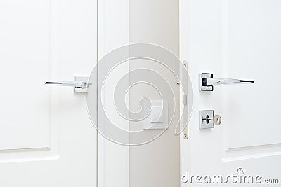 Modern chrome door handle and lock with key. White interior door Stock Photo