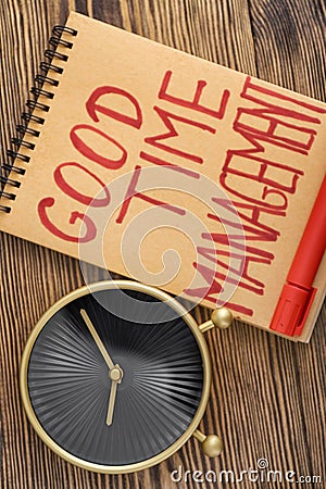 Modern clock and notebook with phrase Good time management on wooden table Stock Photo