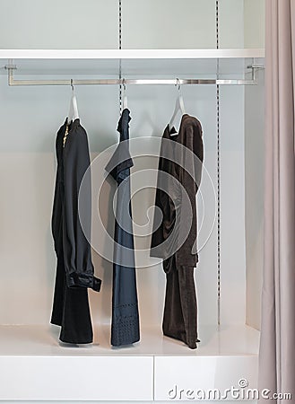 Modern closet with row of black dress hanging in wardrobe. Stock Photo