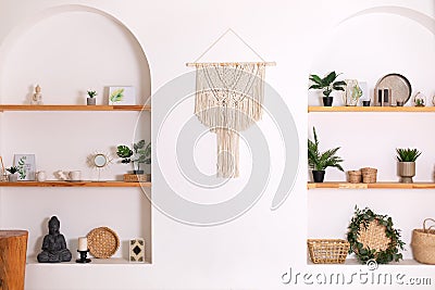 Modern composition of wabi sabi interior with shelf with home decoration and macrame. Stock Photo