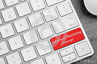 Modern computer keyboard with text AUTOMATED MARKETING CONCEPT on table Stock Photo