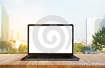 Modern computer,laptop with blank screen on wood table with office window view background Stock Photo