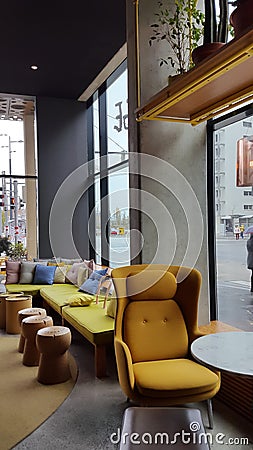 Modern contemporary loft dining room Interior Design with yellow soft chair and barrels instead of tables Stock Photo