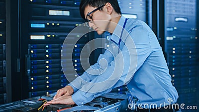 In the Modern Data Center: IT Technician Working with Server Racks, on a Pushcart Installing New H Stock Photo