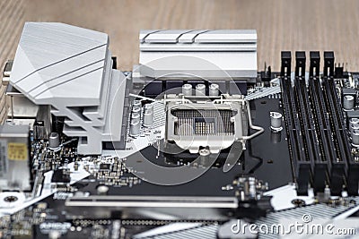 A modern desktop motherboard in black color with a visible socket 1200 for the CPU, memory slots DDR4 and heat sinks. Stock Photo