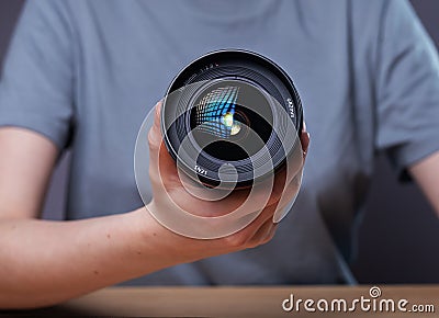 Modern digital camera lens 35 mm in hands of female photographer, close up Stock Photo