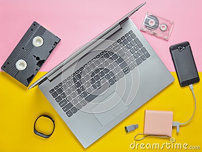 Modern digital gadgets, storage media, devaysy and obsolete analog media devices on a colored paper background. Top view. Flat lay Stock Photo