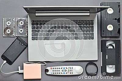 Modern digital gadgets, storage media, devaysy and obsolete analog media devices on a gray paper background. Top view. Flat lay Stock Photo