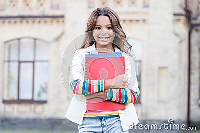 Modern education. Kid smiling girl school student hold workbooks textbooks for studying. Education for gifted children Stock Photo