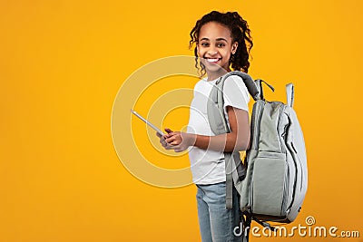 Black girl wearing backpack standing with tablet at studio Stock Photo