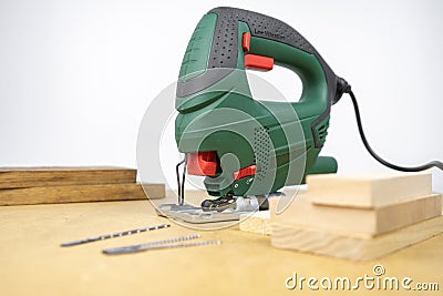 Modern electric jig saw tool for DIY home woodworking. Wood boards on background Stock Photo