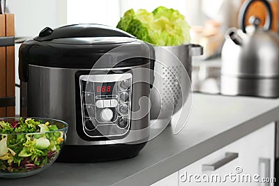 Modern electric multi cooker and food on kitchen countertop. Stock Photo