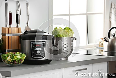 Modern electric multi cooker and food on kitchen countertop. Stock Photo