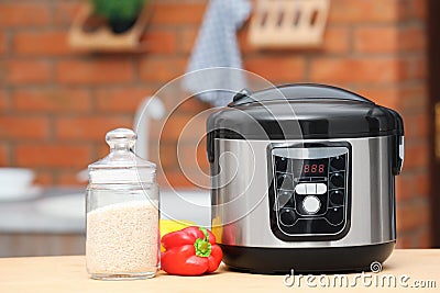 Modern electric multi cooker, jar of rice and peppers Stock Photo