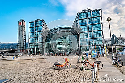 Modern electric scooters, bicycles, bikes in front of modern steel and glass buildings and main train station Haupt Bohnhoff and Editorial Stock Photo