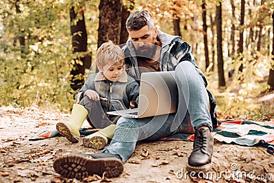 Modern family. Forest school and ecology education. Man bearded father and son with laptop in forest. Ecology upbringing Stock Photo