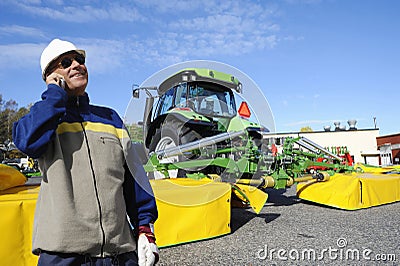 Modern farmer with tractor and ploughs Stock Photo
