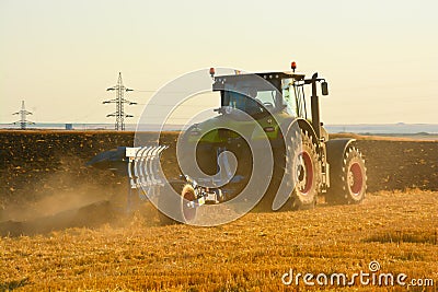 Modern farming with tractor in plowed field Stock Photo