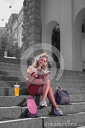 Modern female student feeling happy after skateboarding with her friends in the park Stock Photo