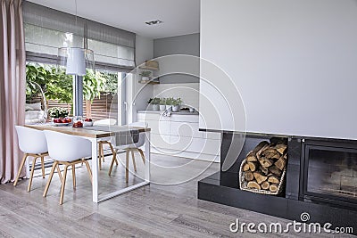 Modern fireplace and wood in a spacious dining room interior wit Stock Photo