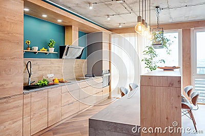 Modern furniture in luxury kitchen. Minimalist scandinavian interior in loft apartment with wooden furniture, lamps Stock Photo