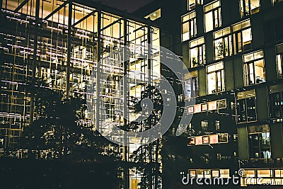 Modern glass office building with yellow lights at night. Modern architecture. Stock Photo