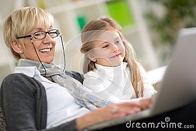 Modern grandmother teaching grandchild how to use laptop Stock Photo