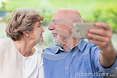 Grandpa and grandma looking for each other and taking selfie for social media account Stock Photo