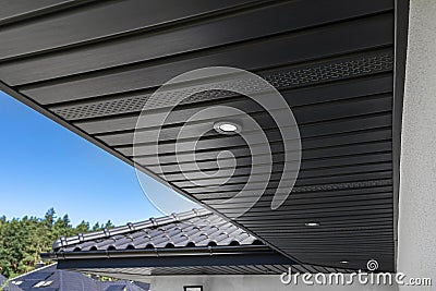 A modern graphite roof lining is attached to the trusses, visible turned on LED lights. Stock Photo