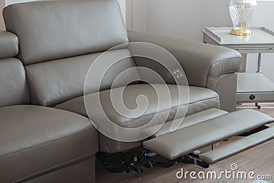 Modern grey leather sofa, with recliner in open position. Stock Photo