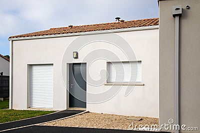 Modern home facade with entrance front door and closed windows shutter Stock Photo