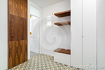 Modern home interior with white walls and cabinets. Hallway with wooden finishing. Stock Photo