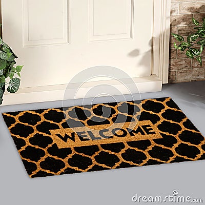 Modern honeycomb patterned yellow black welcome zute doormat outside home with yellow flowers and leaves Stock Photo