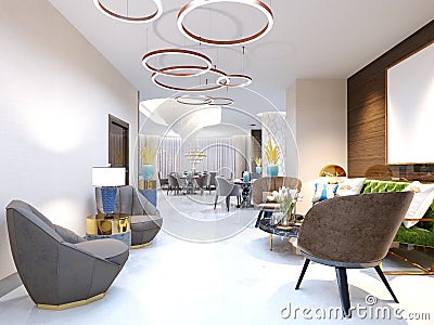 A modern hotel with a reception area and lounge with large upholstered designer chairs and a large chandelier of golden rings Stock Photo