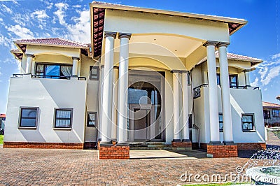 Modern House with blue sky and green grass with a water fountain Stock Photo