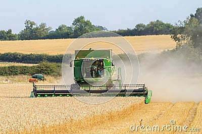 Modern 9780i cts john deere combine harvester cutting crops corn wheat barley working golden field Editorial Stock Photo