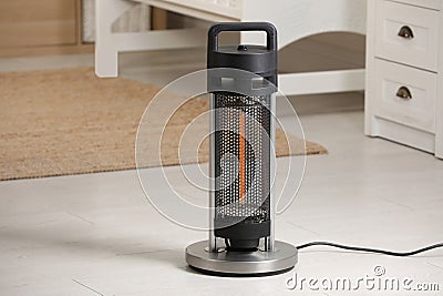 Modern infrared heater on floor in cozy room. Space for text Stock Photo