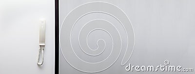 A modern intercom system with a white telephone receiver, displayed on a clean, minimal banner with copy space. The Stock Photo