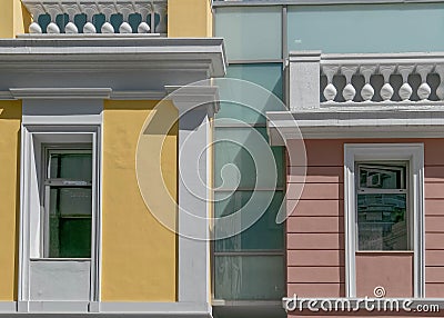 A modern interpretation of classic building design with pink and yellow wall and white frame openings. Stock Photo