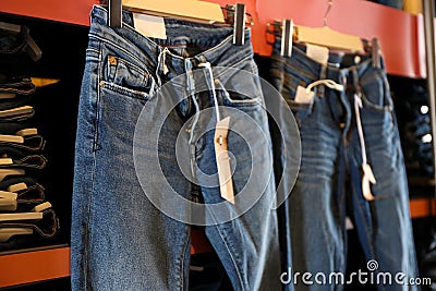 Jeans hanging on shelf in shop Stock Photo