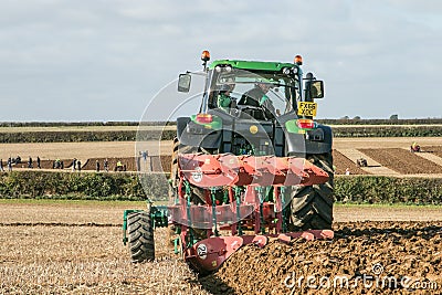 Modern John Deere tractor pulling a plough Editorial Stock Photo