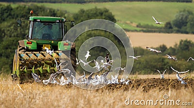 Modern John Deere tractor pulling a plough Editorial Stock Photo