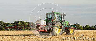 Modern john deere tractor Tractor spraying field stubble crops Editorial Stock Photo