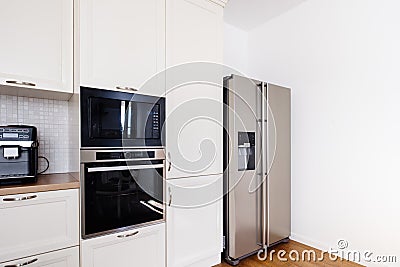 Modern kitchen area, wooden floor with modern refrigerator and appliances Stock Photo