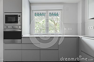 Modern kitchen with gray wooden cabinets and white stone worktops Stock Photo